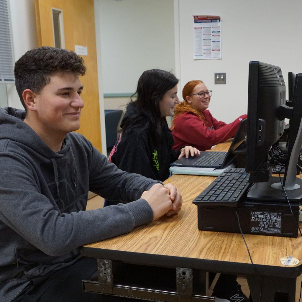 Students sitting computer working on class assignments